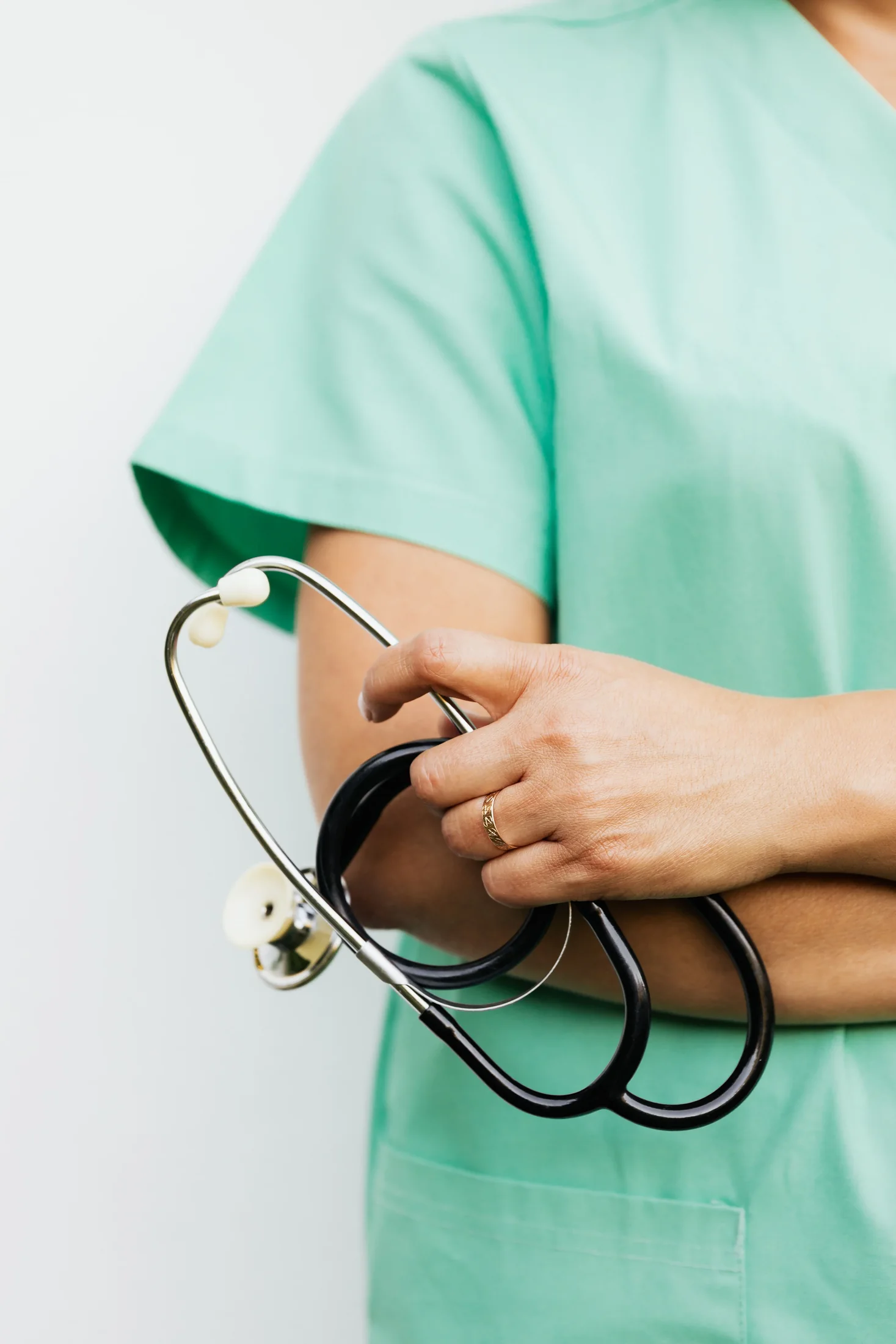 Une soignante en blouse verte, stéthoscope à la main