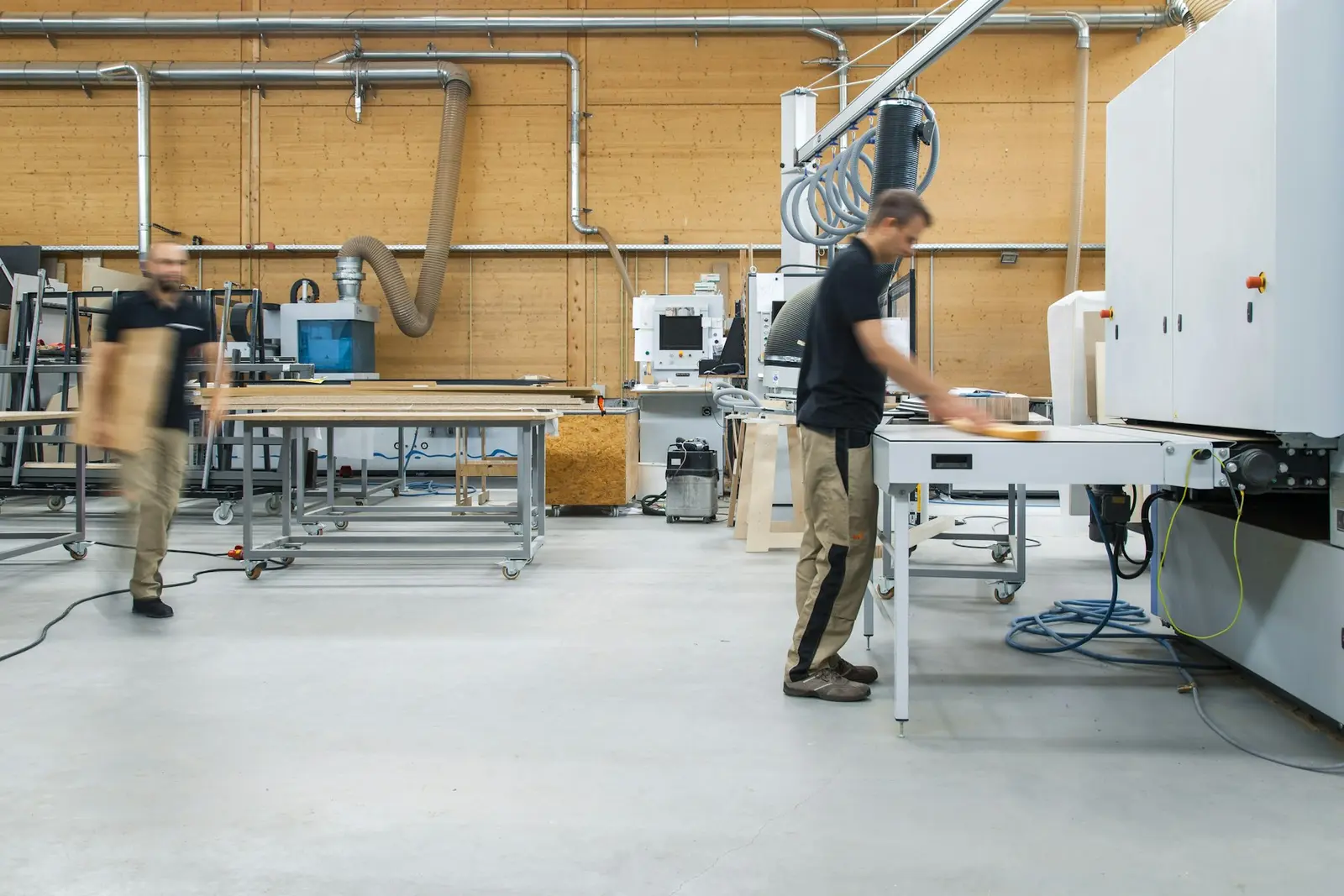 Un atelier de fabrication lumineux, avec deux employés au travail près d'une machine