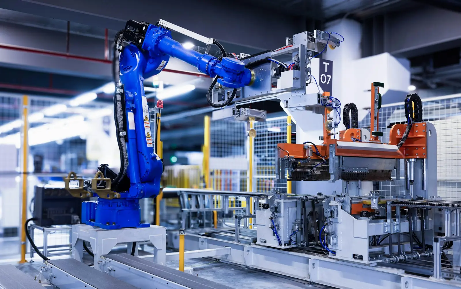 Un bras robotisé bleu au travail sur une ligne de production