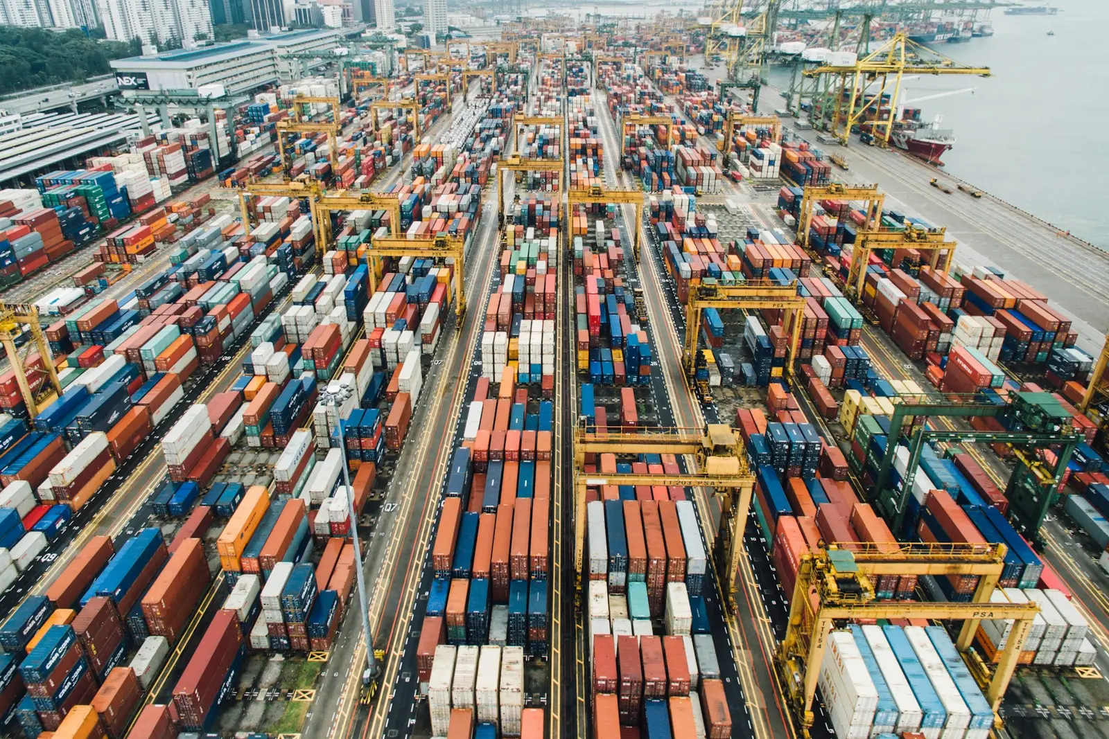 Vue aérienne d’un immense port à conteneurs, avec ses portiques et ses rangées de cargaisons